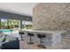 Community outdoor bar with granite counters, barstools, stone accents, and pool views at 4504 Silver Lining St, Sarasota, FL 34238