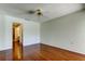 Bedroom with hardwood floors featuring a ceiling fan and an open doorway to the bathroom at 50 Ingrid Pl # 50, Oldsmar, FL 34677