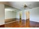 Bright bedroom with hardwood floors, ceiling fan, and a large mirrored wall at 50 Ingrid Pl # 50, Oldsmar, FL 34677