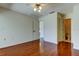 Hardwood bedroom with ceiling fan and a door to an ensuite bathroom at 50 Ingrid Pl # 50, Oldsmar, FL 34677