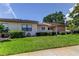 Single-story home featuring well-maintained lawn, landscaping, and beautiful shade tree at 50 Ingrid Pl # 50, Oldsmar, FL 34677