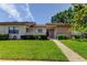 Charming single-story home with a well-maintained lawn, inviting walkway, and manicured landscaping at 50 Ingrid Pl # 50, Oldsmar, FL 34677