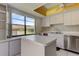 Bright kitchen with white cabinets, island, and large window with neighborhood view at 50 Ingrid Pl # 50, Oldsmar, FL 34677