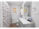 Bathroom with a leaf-patterned shower curtain, gray vanity and wood-look flooring at 5109 N 30Th St, Tampa, FL 33610