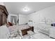 Bedroom features a crib, rocking chair, and bed with white-tiled floors at 5109 N 30Th St, Tampa, FL 33610