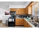 Functional kitchen featuring wood cabinets, stone countertops, and a black appliance package at 5109 N 30Th St, Tampa, FL 33610