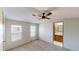 Comfortable bedroom with new carpet, windows for natural light, ceiling fan and a view into the ensuite bathroom at 5824 Coventry Dr, Tampa, FL 33615