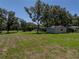 Wide view of backyard with additional structures in the background at 5926 Frontier Dr, Zephyrhills, FL 33540