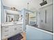 Bathroom with blue walls, white cabinets, and a glass enclosed shower, providing a spa-like experience at 5926 Frontier Dr, Zephyrhills, FL 33540