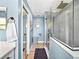 Walk through bathroom featuring a glass enclosed shower and wood look floors at 5926 Frontier Dr, Zephyrhills, FL 33540