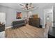 Neutral toned bedroom with ceiling fan, wood look floors and large dresser at 5926 Frontier Dr, Zephyrhills, FL 33540