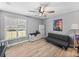 Cozy bedroom with wood-look tile, ceiling fan, and natural light from shuttered windows at 5926 Frontier Dr, Zephyrhills, FL 33540