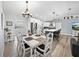 Open dining area with white table set, flowing into a modern kitchen and a living room space at 5926 Frontier Dr, Zephyrhills, FL 33540