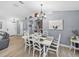 Bright dining room with modern chandelier, decor, and seating for six; wood-look tile flooring at 5926 Frontier Dr, Zephyrhills, FL 33540