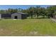 View of metal building surrounded by grassy lawn and trees at 5926 Frontier Dr, Zephyrhills, FL 33540