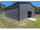 Exterior view of metal building with door, concrete entryway and green grass all around at 5926 Frontier Dr, Zephyrhills, FL 33540