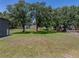 Metal building located on a grassy lot surrounded by trees and other homes at 5926 Frontier Dr, Zephyrhills, FL 33540