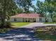 A cozy home showcasing a covered porch with seating, a well-kept lawn, and a paved driveway at 5926 Frontier Dr, Zephyrhills, FL 33540