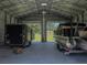 Metal building interior with boat, trailer, and open doors to the grassy lawn at 5926 Frontier Dr, Zephyrhills, FL 33540