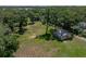 Expansive view of the property with mature trees, open lawn space, and a detached metal building at 5926 Frontier Dr, Zephyrhills, FL 33540