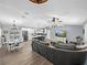 Open-concept living area with modern furnishings, a large TV, dining area, and a view of the kitchen at 5926 Frontier Dr, Zephyrhills, FL 33540