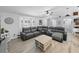 Comfortable living room with a gray sectional, bright bay window, and unique coffee table at 5926 Frontier Dr, Zephyrhills, FL 33540