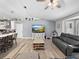Spacious living room with modern ceiling fan, wood-look tile flooring, and comfortable gray couch at 5926 Frontier Dr, Zephyrhills, FL 33540