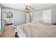Bedroom with ensuite bathroom access featuring a large bed, ceiling fan, and ample natural light at 5926 Frontier Dr, Zephyrhills, FL 33540