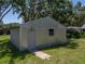 View of a modern outbuilding on lush lawn featuring a secure door and small window at 5926 Frontier Dr, Zephyrhills, FL 33540