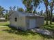 Side view of a modern outbuilding featuring both a secure door and convenient garage door at 5926 Frontier Dr, Zephyrhills, FL 33540