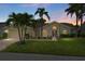 Charming single-story home featuring lush landscaping and a welcoming front entrance at dusk at 6009 Cedarwood Ln, Bradenton, FL 34203