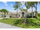 Well-maintained single-Gathering home with mature landscaping, arched windows, and a two-car garage at 6009 Cedarwood Ln, Bradenton, FL 34203