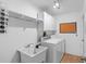Laundry room featuring a utility sink, a washer and dryer, and ample storage space at 6009 Cedarwood Ln, Bradenton, FL 34203