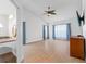 Bright living room with wood floors, large windows, and a vaulted ceiling with a ceiling fan at 6009 Cedarwood Ln, Bradenton, FL 34203