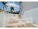 Backyard view of a house with a white fence, palm trees, and an area for lounge chairs at 601 2Nd St, Indian Rocks Beach, FL 33785