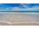 Beautiful view of ocean with white waves approaching sandy beach on a sunny day at 601 2Nd St, Indian Rocks Beach, FL 33785