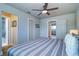 Bedroom featuring a fan and a comfortable bed with striped comforter and access to the bathroom at 601 2Nd St, Indian Rocks Beach, FL 33785