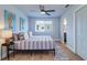 Bright bedroom featuring two seahorse wall hangings, fan and a comfortable bed with striped comforter at 601 2Nd St, Indian Rocks Beach, FL 33785