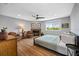 Bedroom with wood floors, ceiling fan, fireplace, and large window offering natural light at 601 2Nd St, Indian Rocks Beach, FL 33785