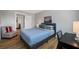 Bedroom with wood floors, ceiling fan, desk, seating, and large window offering natural light at 601 2Nd St, Indian Rocks Beach, FL 33785