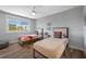 Bedroom with two twin beds, wood floors, ceiling fan, and large window offering natural light at 601 2Nd St, Indian Rocks Beach, FL 33785