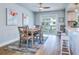 Bright dining area with flamingo art, wood flooring, seating for four and sliding glass doors at 601 2Nd St, Indian Rocks Beach, FL 33785