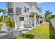 Exterior of the home with a spiral staircase leading to a deck, and a well-maintained yard at 601 2Nd St, Indian Rocks Beach, FL 33785