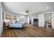 Bright main bedroom offers wood floors, ceiling fan, ensuite bathroom, and sliding barn door at 601 2Nd St, Indian Rocks Beach, FL 33785