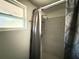 This bathroom features a window, shower with a patterned tile wall, and a shower curtain at 6426 S Himes Ave, Tampa, FL 33611