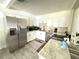Clean kitchen featuring stainless steel appliances, white cabinetry, and light-colored flooring at 6426 S Himes Ave, Tampa, FL 33611