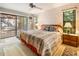 This bedroom features a large bed with side tables and access to the screened in lanai at 70 Morning Dove Pl, Oldsmar, FL 34677
