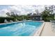 Beautiful community pool with clubhouse, surrounded by lounge chairs and lush landscaping at 70 Morning Dove Pl, Oldsmar, FL 34677