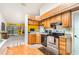Efficient kitchen showcases wood cabinets, stainless steel appliances, and connection to living area at 70 Morning Dove Pl, Oldsmar, FL 34677