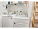 This laundry room features a washer and dryer, overhead storage shelves, and neutral colored walls at 70 Morning Dove Pl, Oldsmar, FL 34677